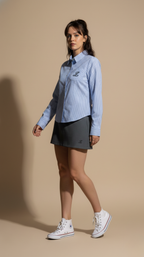 Woman wearing a blue striped shirt and black skirt on a beige background