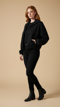Woman wearing a black outfit on a beige background